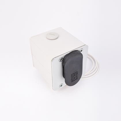 Vit fyrkantig elektrisk enhet med svart gummitätning, fyra hörnskruvar och kabel på baksidan.