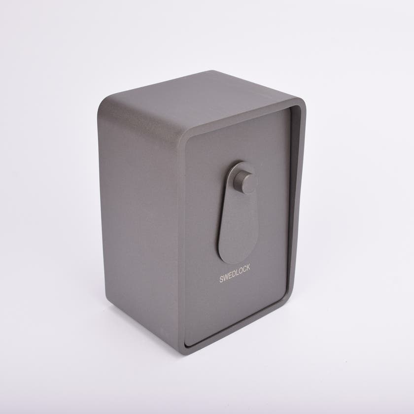 Grått fasadnyckelskåp i metall med rundade hörn och vridbar skyddskåpa.