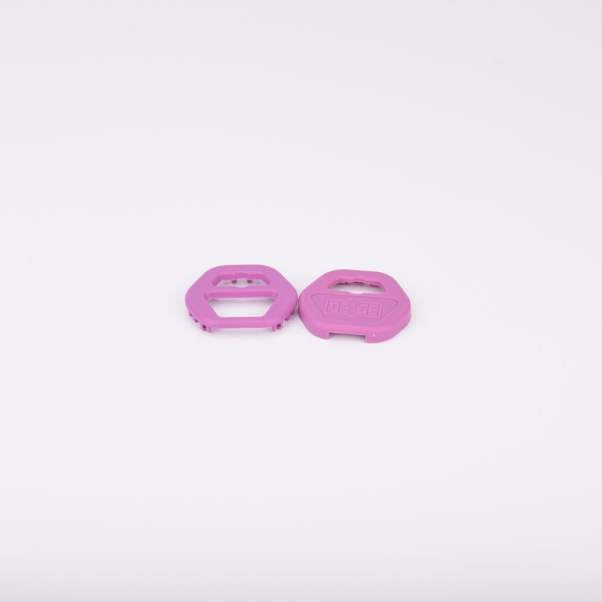 Två rosa nyckelgrepp i plast med hexagonal form och utskurna sektioner.