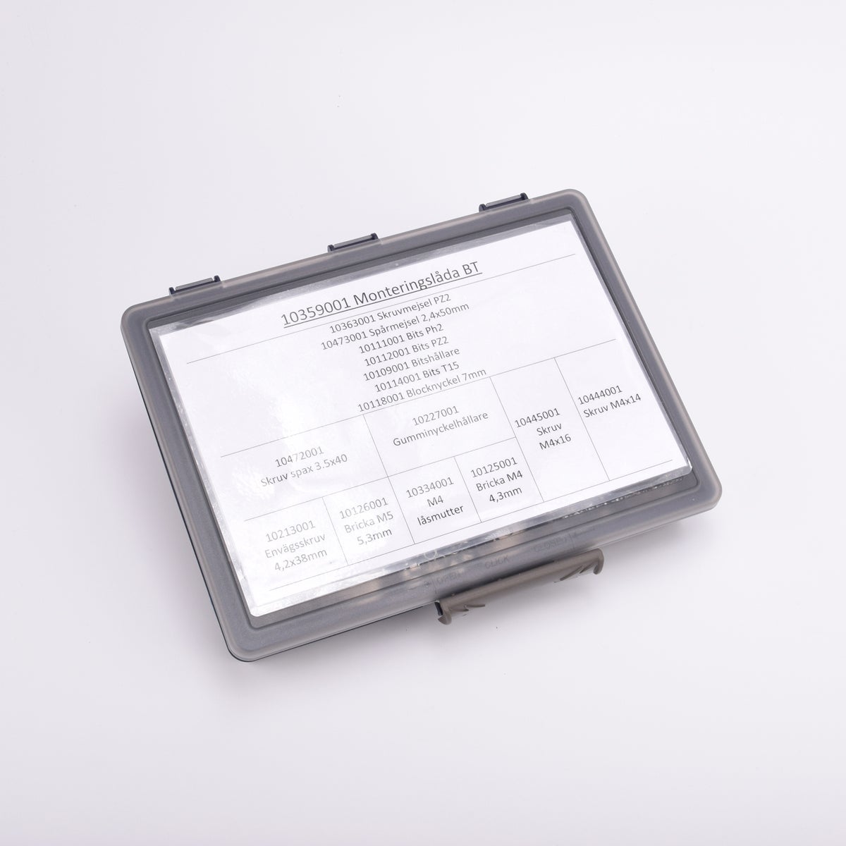 En grå sortimentslåda täckt med en vit översikt med vad som ligger i de olika facken.