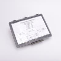 En grå sortimentslåda täckt med en vit översikt med vad som ligger i de olika facken.