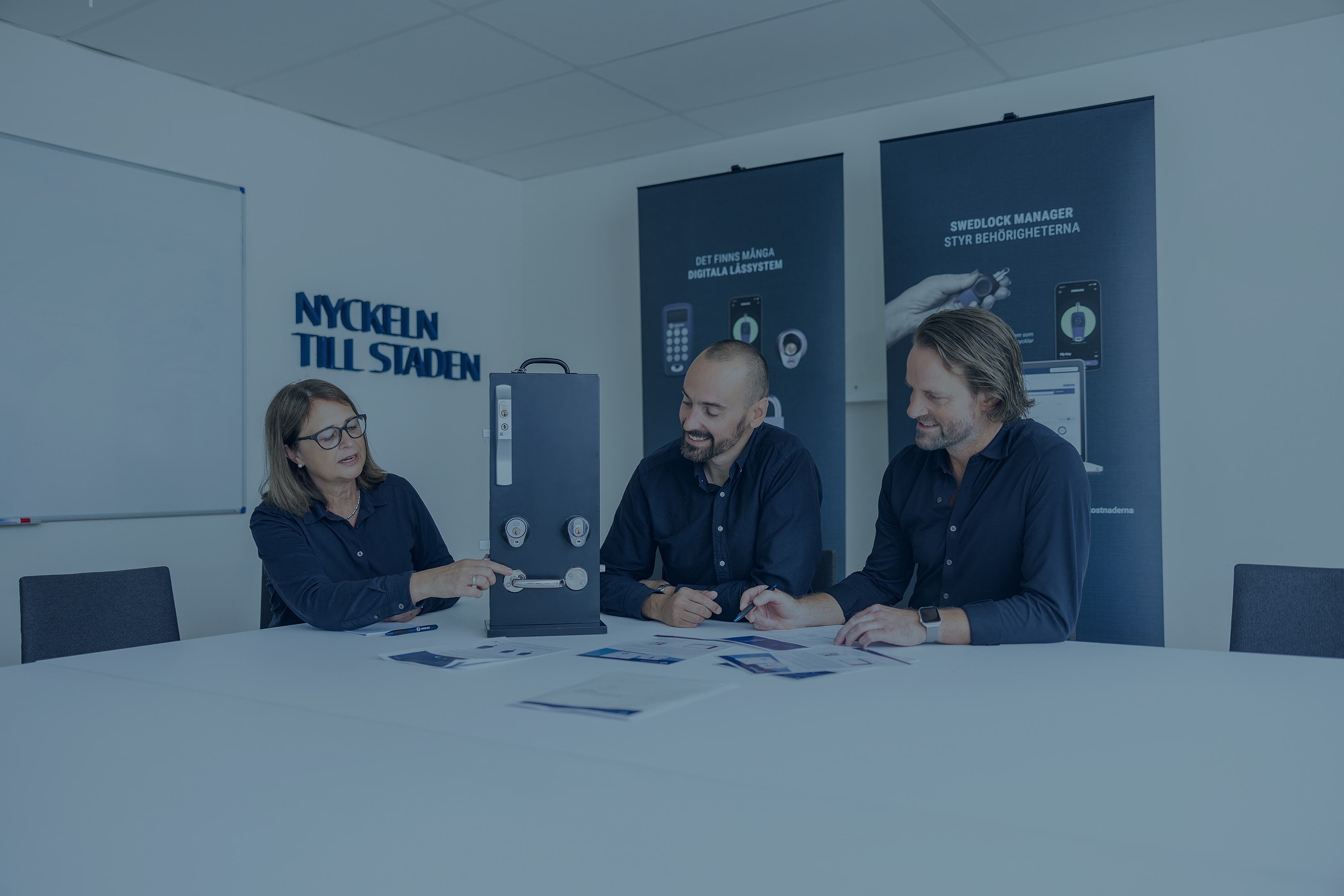 Tre personer som sitter i et møterom