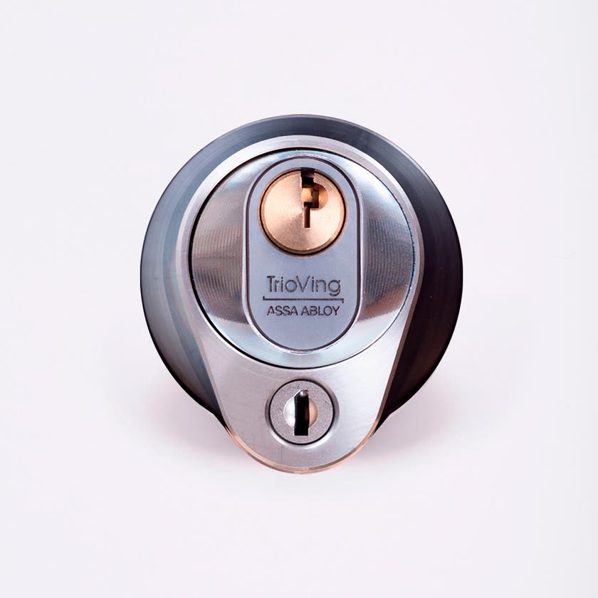 Närbild av ett silverfärgat säkerhetslås med två nyckelhål, placerade ovanför varandra.