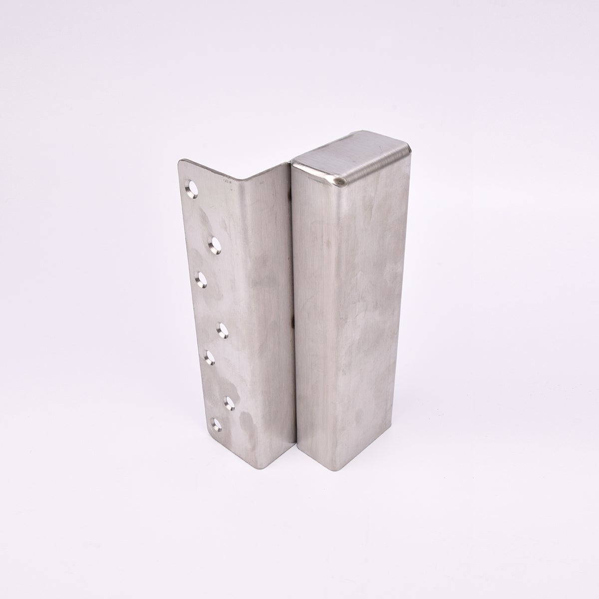 En L-formad nyckelförvaringsenhet med flera cirkulära hål längs ena sidan. 