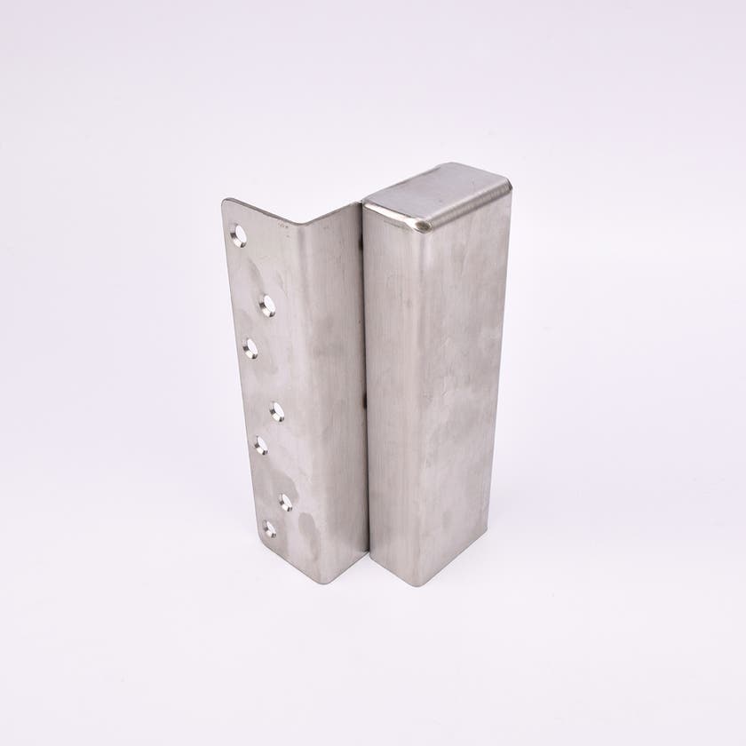 En L-formad nyckelförvaringsenhet med flera cirkulära hål längs ena sidan.