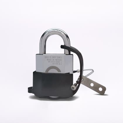 Rostfritt hänglås monterat i ett svart skydd med tillhörande metallfästen och vajer.