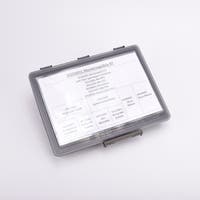 En grå sortimentslåda täckt med en vit översikt med vad som ligger i de olika facken.