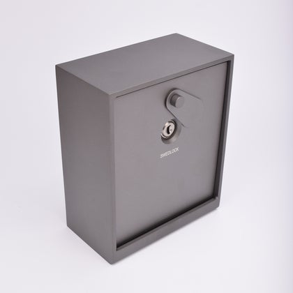 Grått fasadnyckelskåp i metall med vridbar skyddskåpa.