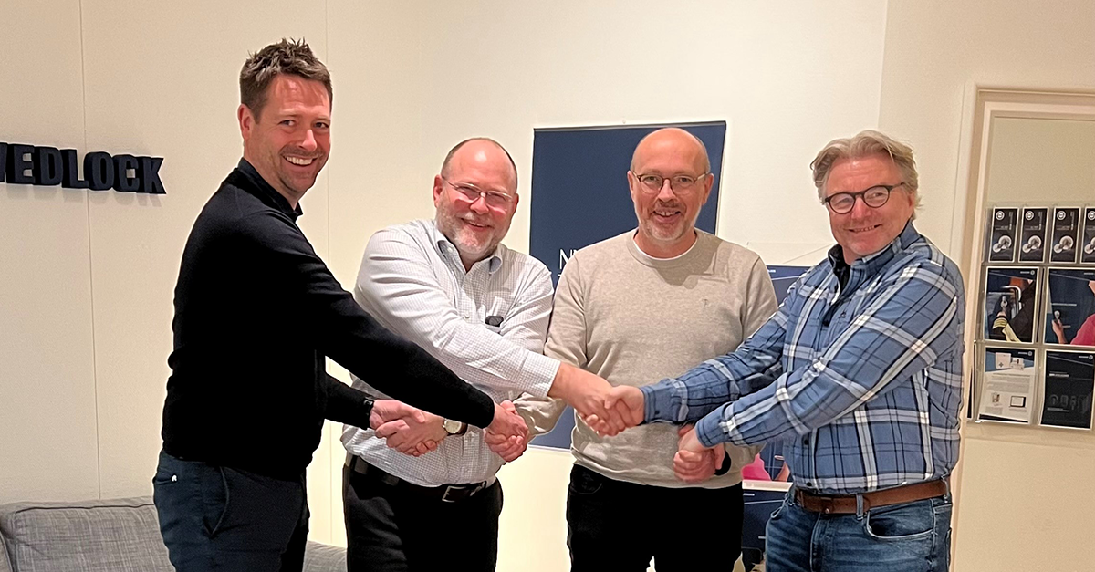 Fyra leende personer som skakar hand med varandra