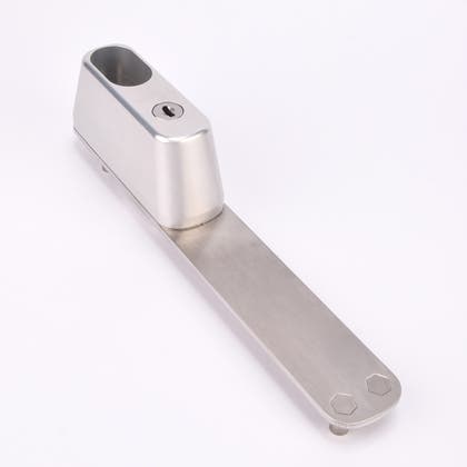 Rektangulärt silverfärgat låshus med ovalt urtag, ett nyckelhål i nedre delen samt en lång metallplatta.