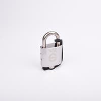 Silverfärgat hänglås med rektangulär kropp och rund bygel. En svart gummirem är fäst från hänglåsets nedre del till bygeln.