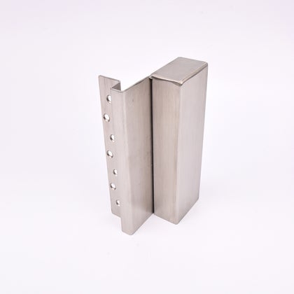 En L-formad nyckelförvaringsenhet med flera cirkulära hål längs ena sidan. 
