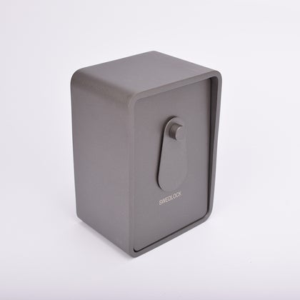 Grått fasadnyckelskåp i metall med rundade hörn och vridbar skyddskåpa.