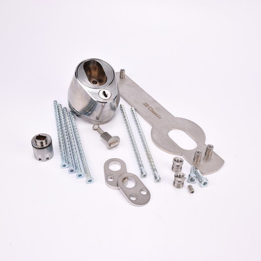 Droppformad låscylinder med ovalt urtag, samt nyckelhål och monteringssats med metallkomponenter för montering, inklusive skruvar, muttrar och brickor.