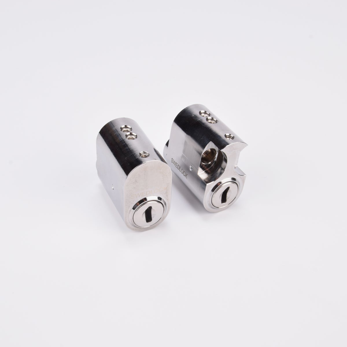 Två ovala cylinderlås i metall med nyckelhål.