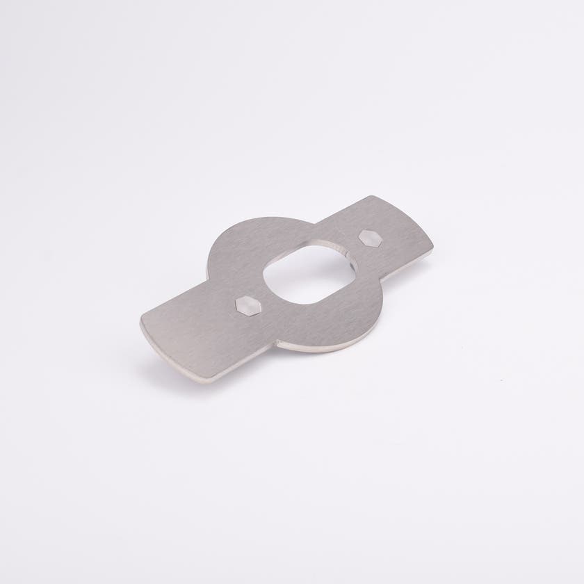 Monterningsplåt med rektangulära utskott på båda sidor av en central cirkelsektion med ovalt urtag och två sexkantiga hål.