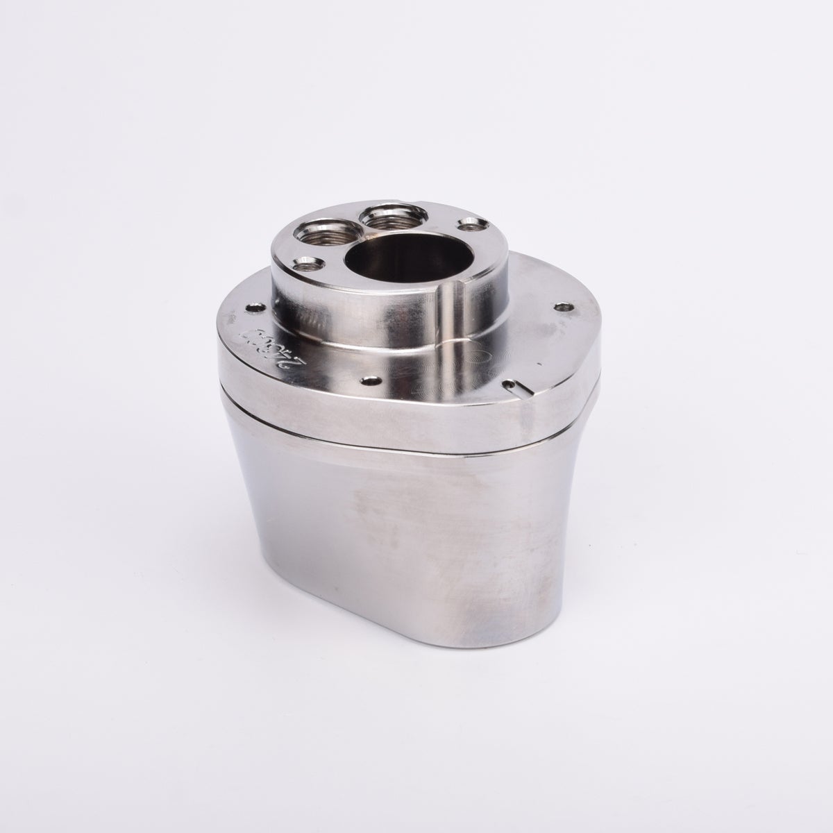 Silverfärgad metallkropp med rundad bas och flera hål på ovansidan.