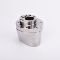 Silverfärgad metallkropp med rundad bas och flera hål på ovansidan.