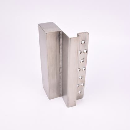 En L-formad nyckelförvaringsenhet med flera cirkulära hål längs ena sidan.