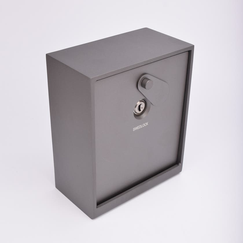 Grått fasadnyckelskåp i metall med vridbar skyddskåpa.