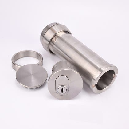 Cylindrisk silverfärgat nyckelfacksrör samt ett runt lås, en rund bricka och en rund ring.