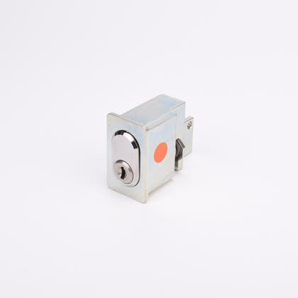 Rektangulärt låshus i metall med blank yta, cylinderformad låskolv framtill.