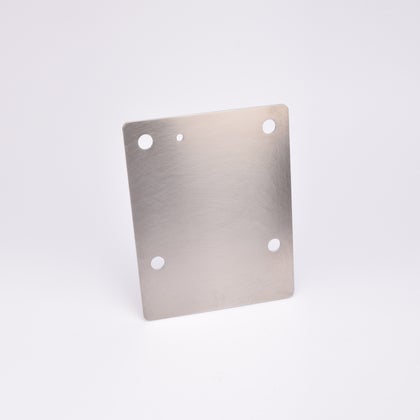 Rektangulär metallplatta med fyra runda hål.