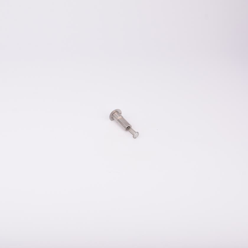 En metallisk cylinderformad komponent med en fjäder som sticker ut från ena änden.