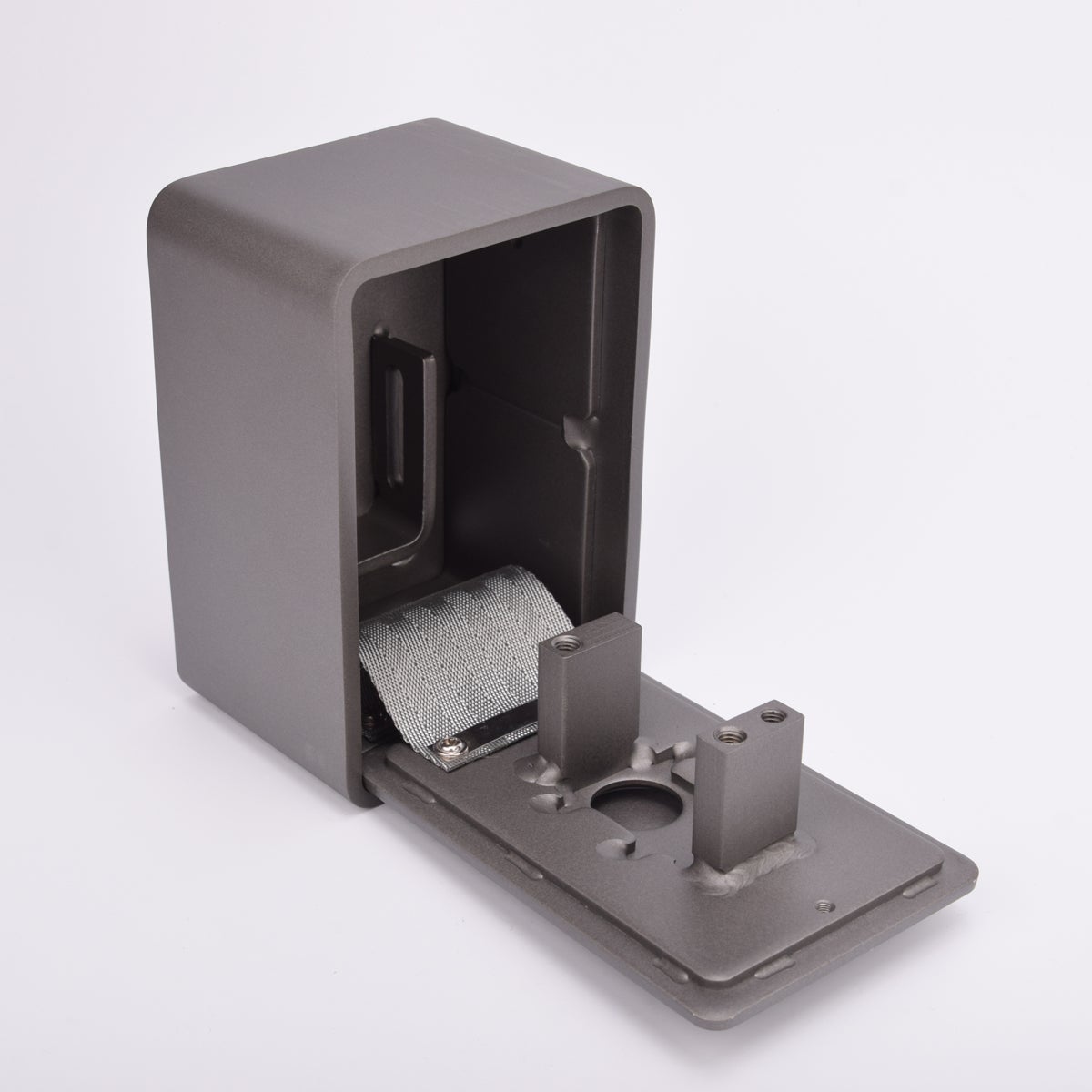 Grått fasadnyckelskåp i metall med rundade hörn och helt utfälld lucka.