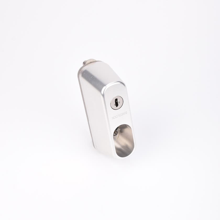 Rektangulärt silverfärgat låshus med ovalt urtag samt ett nyckelhål i övre delen.