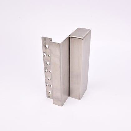 En L-formad nyckelförvaringsenhet med flera cirkulära hål längs ena sidan. 