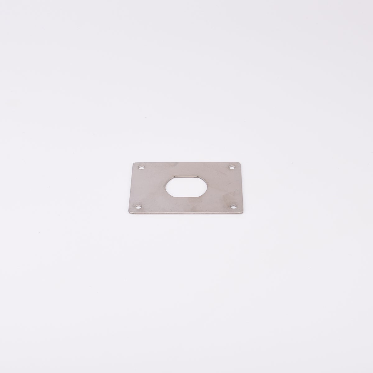 En rektangulär metallplatta med hål i mitten.
