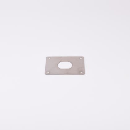 En rektangulär metallplatta med hål i mitten.