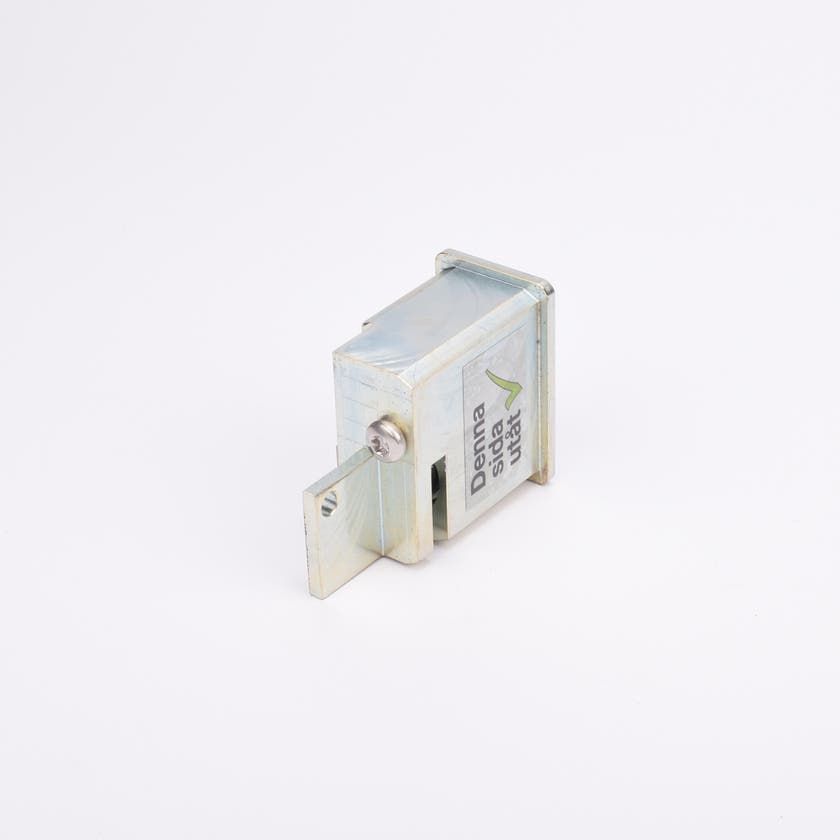 Metalliskt lås med utskjutande regel och etikett med texten ”Denna sida utåt” samt grön bock.