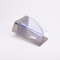 Väderskydd med rektangulär bas och vinklad ovansida med ett cirkulärt hål. Med genomskinlig plast över.