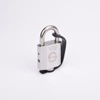 Silverfärgat hänglås med rektangulär kropp och rund bygel. En svart gummirem är fäst från hänglåsets nedre del till bygeln.