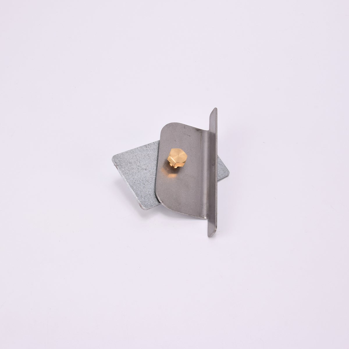 Två metall föremål med vinklad kant, fästa med guldfärgad skruv.