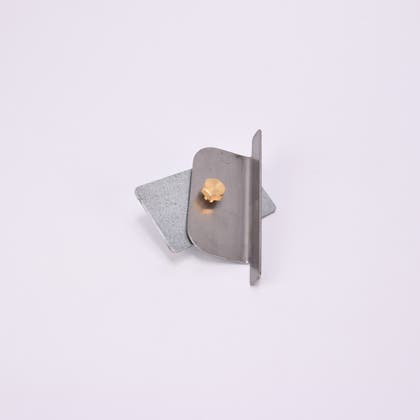 Två metall föremål med vinklad kant, fästa med guldfärgad skruv.