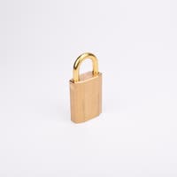 Mässingsfärgat hänglås med rektangulär kropp och rund bygel.