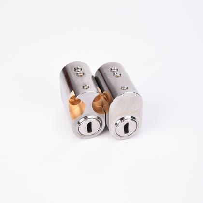 Två ovala cylinderlås i metall med nyckelhål.