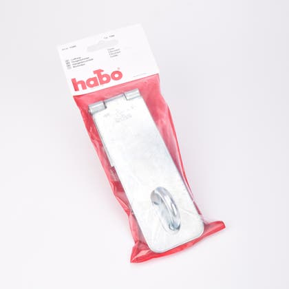 En metall hasp liggandes i en platspåse mot en röd bakgrund.