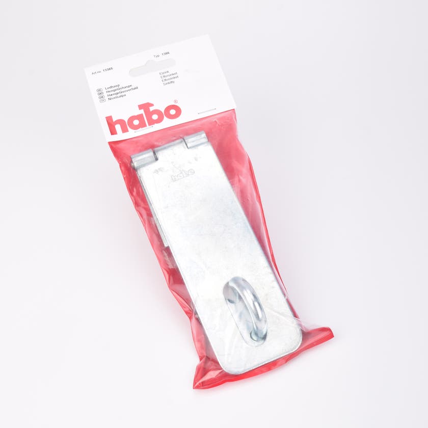 En metall hasp liggandes i en platspåse mot en röd bakgrund.