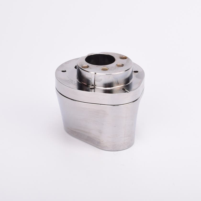 Silverfärgad metallkropp med rundad bas och flera hål på ovansidan.