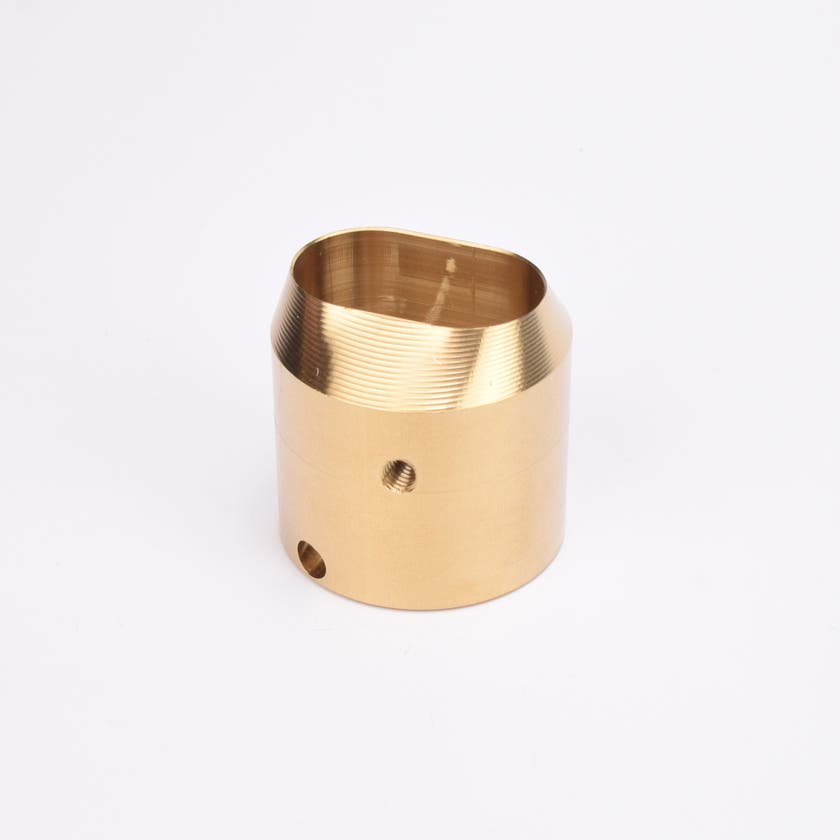 Mässingsfärgat utfyllnadsadapter i metall med snedskuren topp som bildar en oval öppning.
