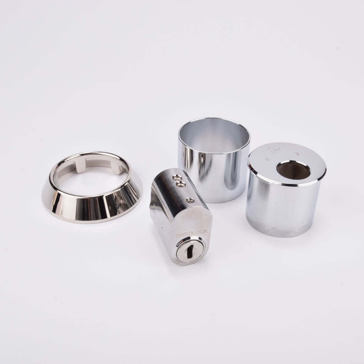 Låssats i krom med cylinder och tre runda täckhylsor.