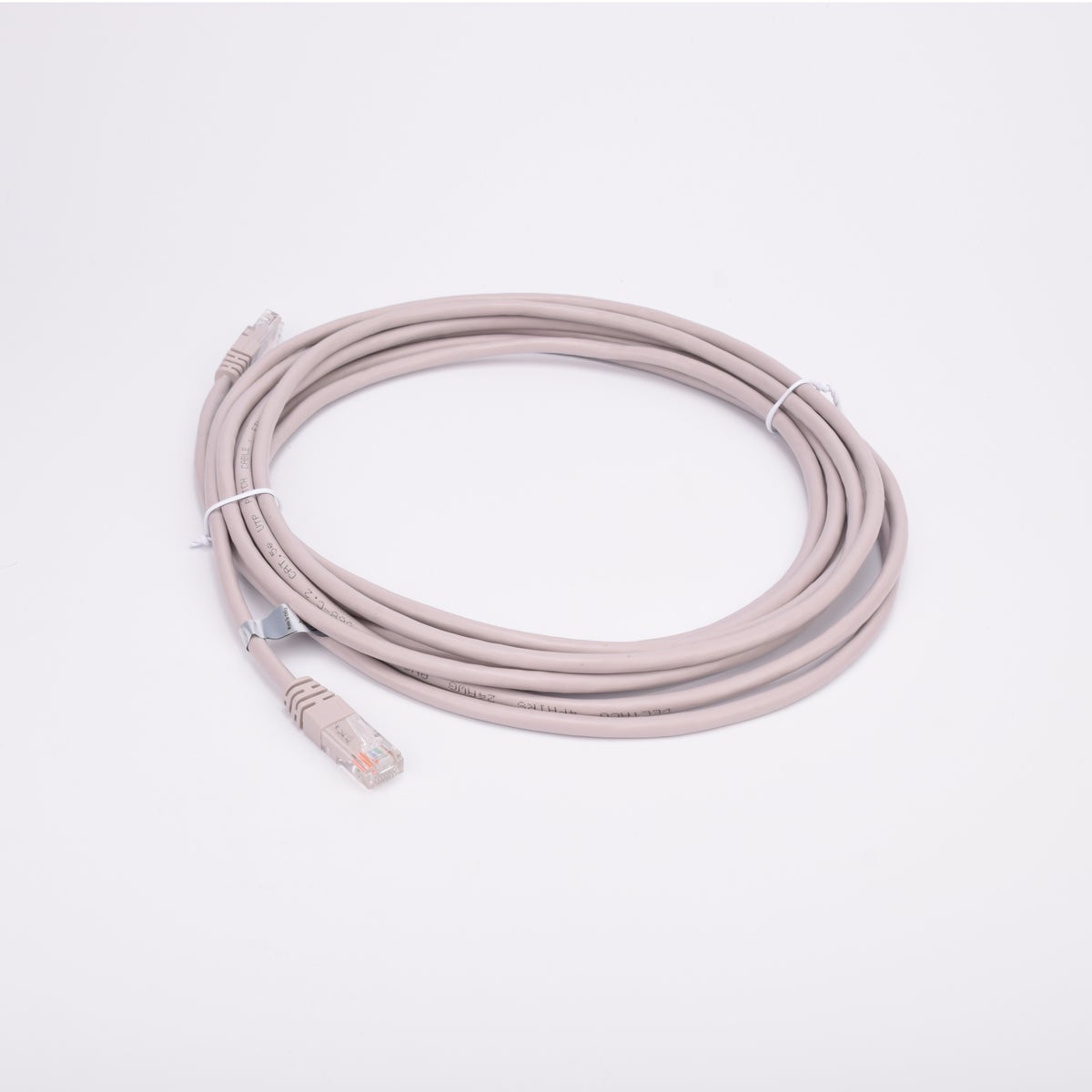 Vit ihoprullad nätverkskabel med kontakter i ändarna.