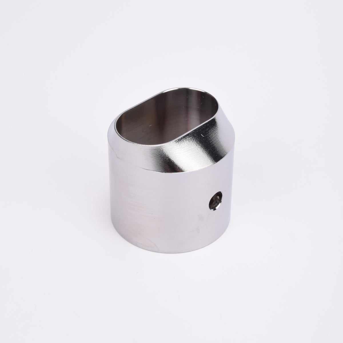 Cylindrisk utfyllnadsadapter i silverfärgad metall med sendskuren topp som bildare en oval öppning.