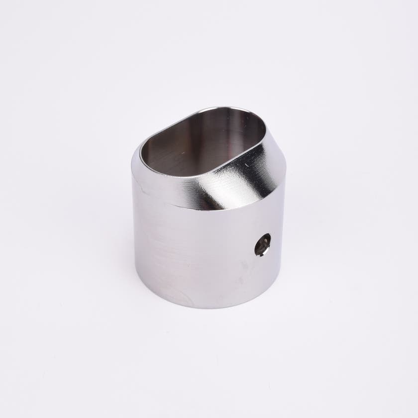 Cylindrisk utfyllnadsadapter i silverfärgad metall med sendskuren topp som bildare en oval öppning.