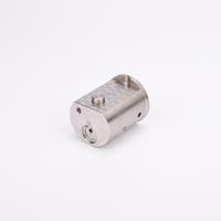 Metallisk cylindrisk komponent med platt topp och botten, försedd med hål och urtag.