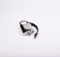 Silverfärgat hänglås med rektangulär kropp och rund bygel. En svart gummirem hänger från hänglåsets bygel.